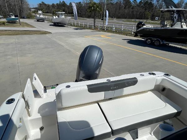 Slide: The Image of 2024 Robalo R222 Explorer boat rear seating and outboard motor in a marina. - 5