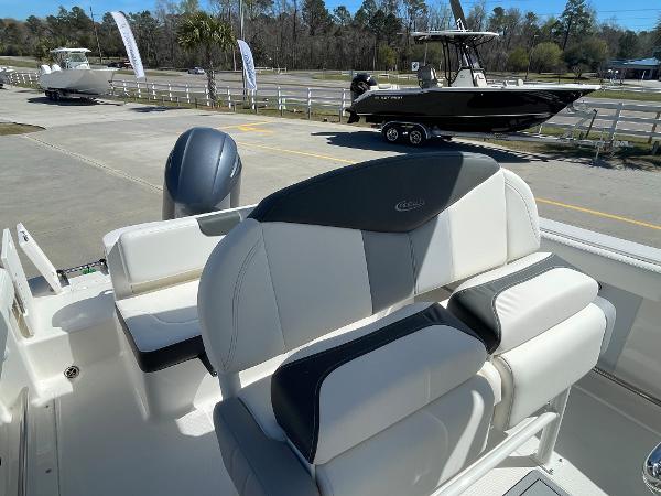 Slide: The Image of 2024 Robalo R222 Explorer boat interior with cushioned seating and outboard motor. - 6