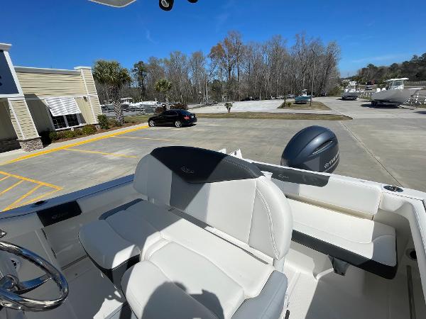 Slide: The Image of 2024 Robalo R222 Explorer boat with white seating and outboard motor in parking lot. - 8