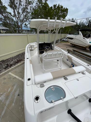 Slide: The Image of 2019 Robalo R242 Center Console boat with T-top and seating, docked outdoors. - 15