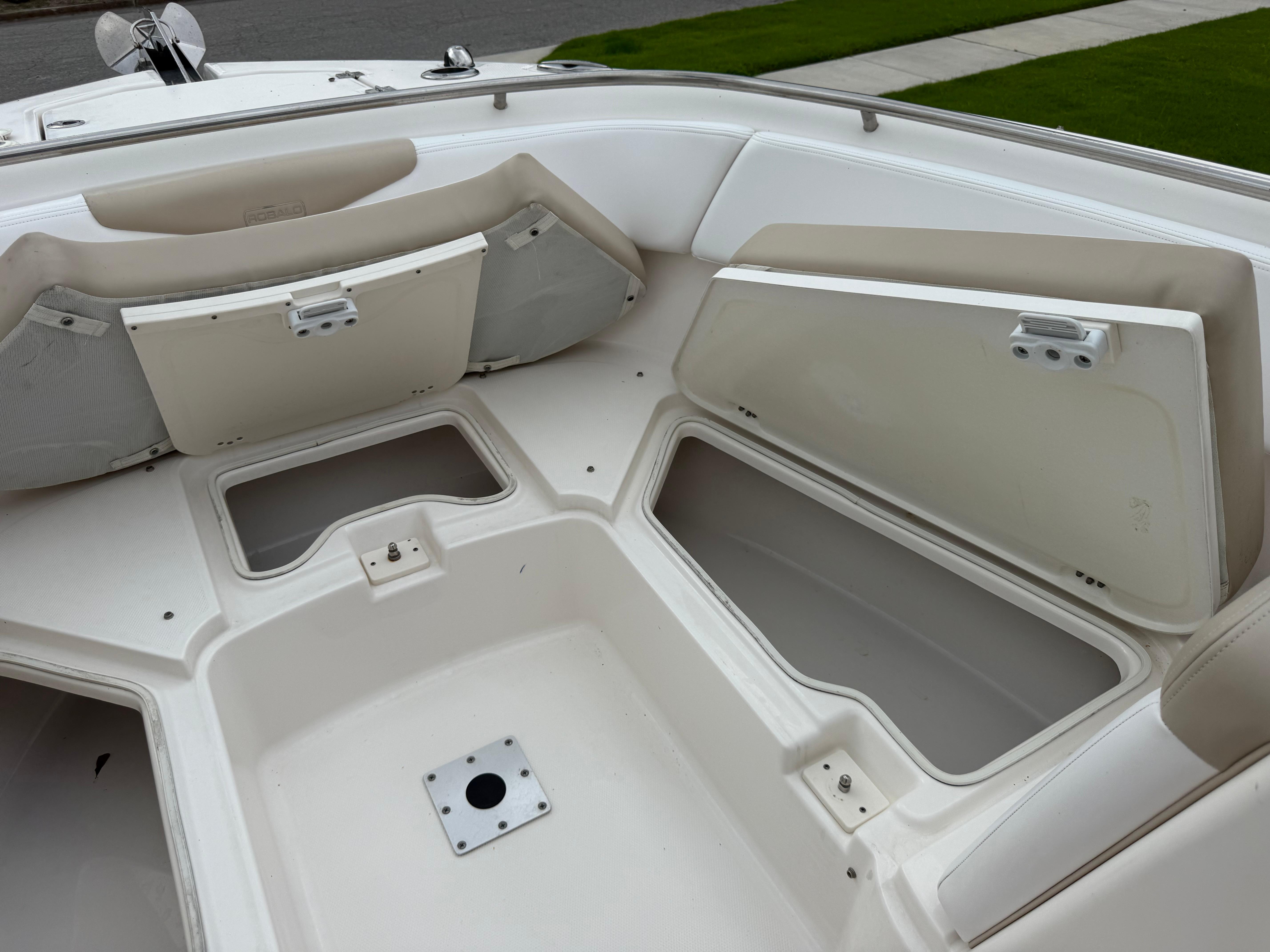 Slide: The Image of 2018 Robalo R247 Dual Console boat with open storage compartments and seating area. - 24