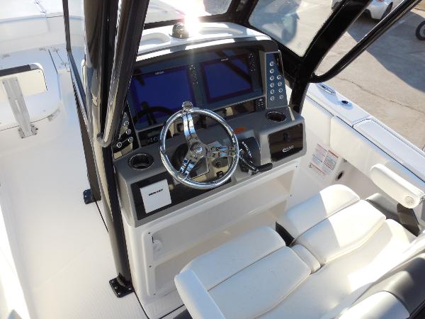 Slide: The Image of 2024 Robalo R266 Cayman boat helm with dual displays and steering wheel. - 6