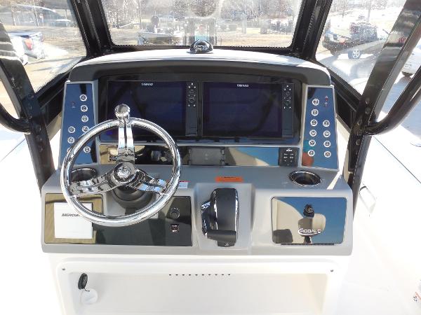 Slide: The Image of 2024 Robalo R266 Cayman boat dashboard with dual Simrad displays and chrome steering wheel. - 9