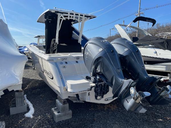Slide: The Image of 2024 Robalo R270 Center Console boat with dual outboard engines, parked on blocks. - 2