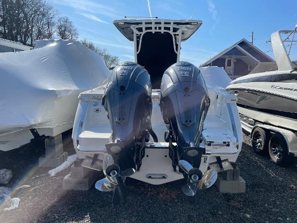 Slide: The Image of 2024 Robalo R270 Center Console with dual outboard motors, docked outdoors. - 4