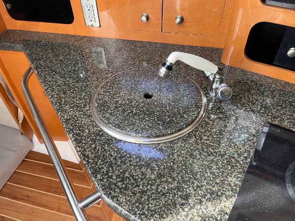 Slide: The Image of 2009 Robalo R305 Walkaround boat kitchen with granite countertop and sink. - 32