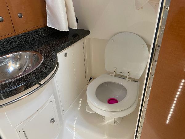 Slide: The Image of 2009 Robalo R305 Walkaround boat bathroom with toilet and sink. - 38