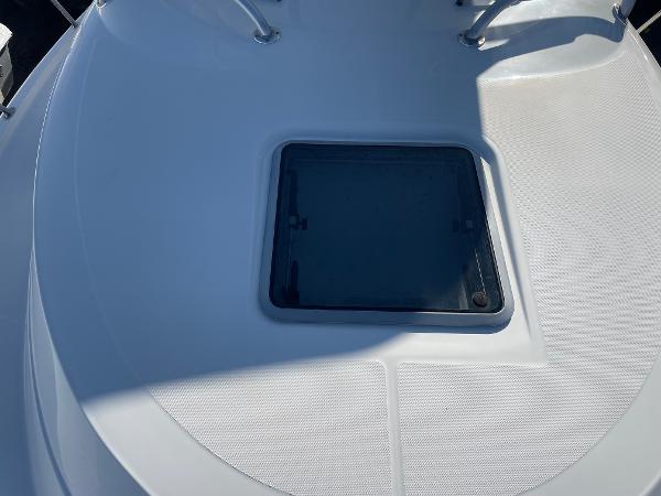 Slide: The Image of 2009 Robalo R305 Walkaround boat deck with hatch, featuring sleek design and sturdy railings. - 48