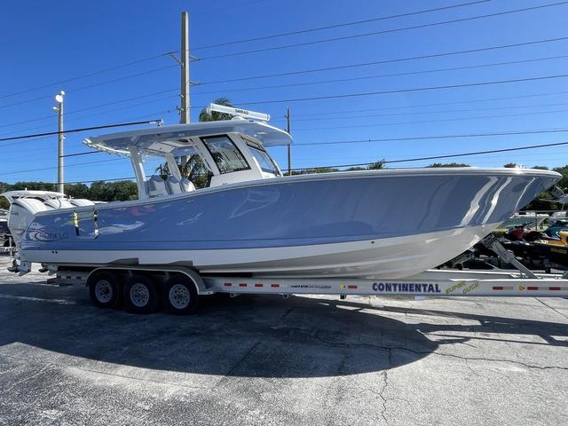 Slide: The Image of 2024 Robalo R360 boat on a Continental trailer in a parking lot. - 2
