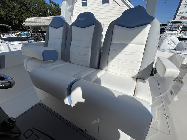 Slide: The Image of 2024 Robalo R360 boat with three cushioned seats in white and blue. - 21