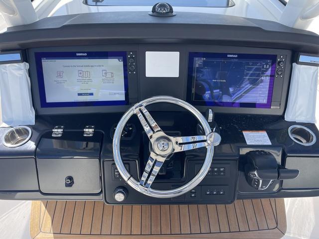 Slide: The Image of 2024 Robalo R360 boat dashboard with dual Simrad displays and steering wheel. - 25