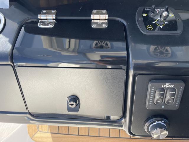 Slide: The Image of Control panel of 2024 Robalo R360 boat with storage compartment and Lenco trim tab controls. - 33