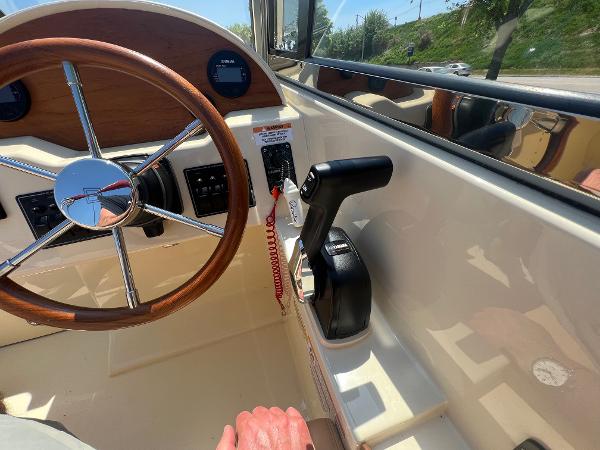 Slide: The Image of 2021 Rossiter 20 Coastal Cruiser helm with steering wheel and throttle controls. - 29