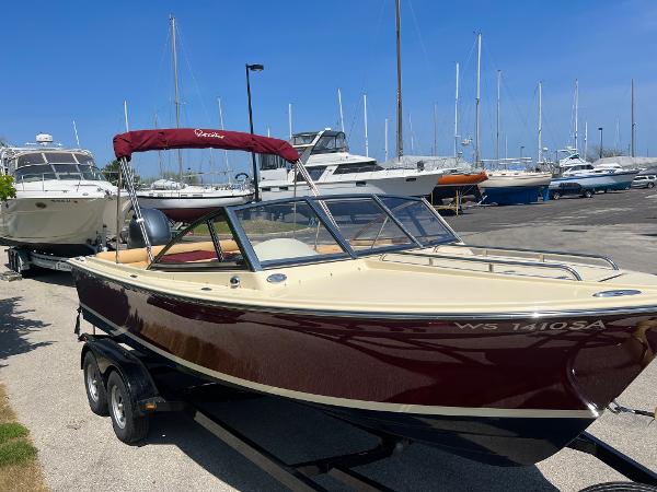Slide: The Image of 2021 Rossiter 20 Coastal Cruiser boat with maroon hull and trailer at marina. - 3