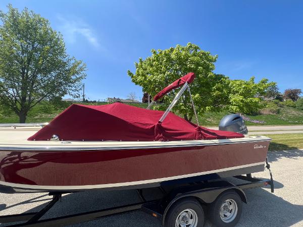 Slide: The Image of 2021 Rossiter 20 Coastal Cruiser boat with red cover on trailer, parked outdoors. - 4