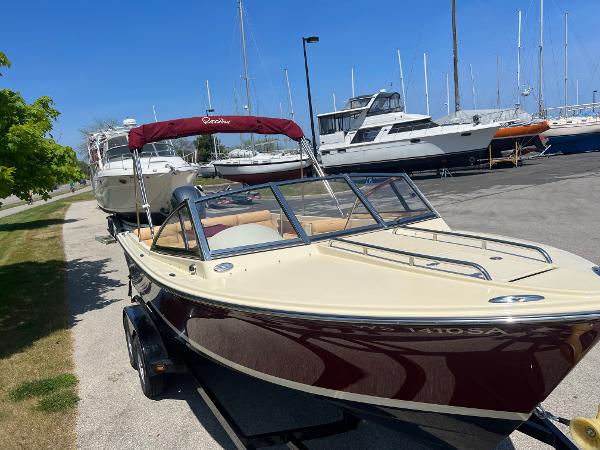 Slide: The Image of 2021 Rossiter 20 Coastal Cruiser boat with maroon hull and canopy, docked at marina. - 6