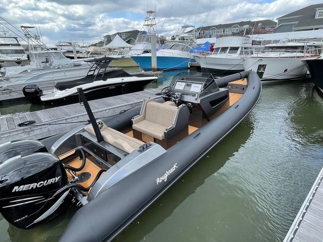 Slide: The Image of 2022 Roughneck RIB 1010 boat docked, featuring Mercury engines, in a marina setting. - 1