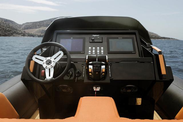 Slide: The Image of 2022 Roughneck RIB 1010 boat dashboard with steering wheel and navigation screens. - 12