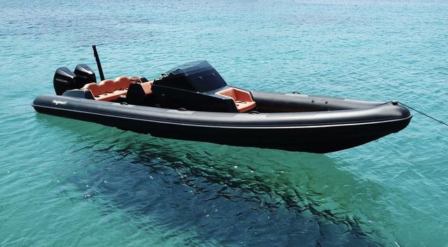 Slide: The Image of Roughneck RIB 1010 boat, 2022 model, floating on clear turquoise water. - 18