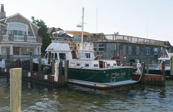 Slide: The Image of 2000 Sabreline 47 Motor Yacht docked near waterfront homes. - 1