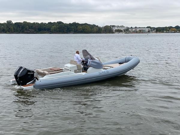 Slide: The Image of 2024 SACS Strider 900 inflatable boat cruising on a calm lake. - 0