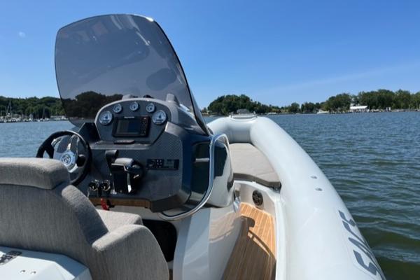 Slide: The Image of 2024 SACS Strider 900 boat on a lake with a clear blue sky. - 6