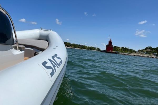 Slide: The Image of 2024 SACS Strider 900 boat on water near red lighthouse. - 9