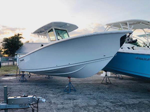 Slide: The Image of 2023 Sailfish 272 CC center console boat on display at a marina. - 0