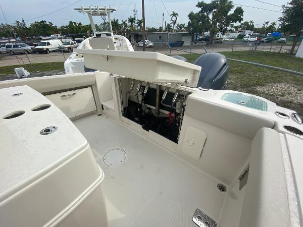 Slide: The Image of 2023 Sailfish 272 CC boat with open storage compartment and visible engine components. - 15