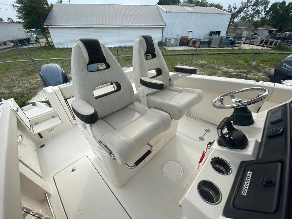 Slide: The Image of 2023 Sailfish 272 CC boat interior with dual captain's chairs and steering console. - 21