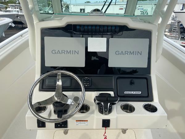 Slide: The Image of 2023 Sailfish 272 CC boat dashboard with dual Garmin displays and steering wheel. - 23