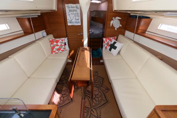 Slide: The Image of Interior of 2013 Salona 38 sailboat with white seating and decorative pillows. - 21
