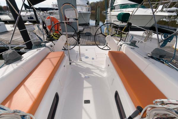 Slide: The Image of Cockpit of a 2013 Salona 38 sailboat with orange cushions, docked at a marina. - 8