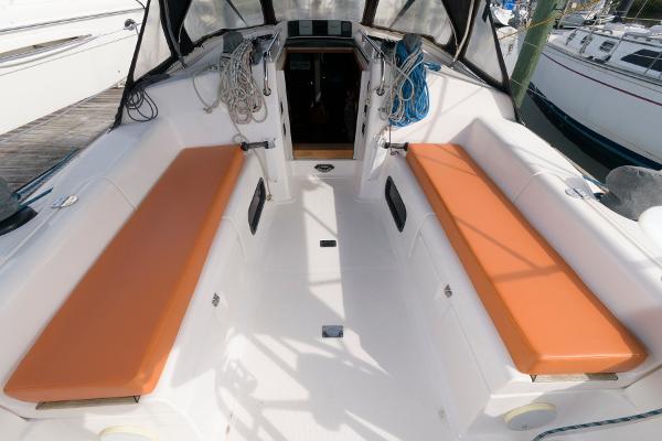 Slide: The Image of Cockpit of 2013 Salona 38 sailboat with orange cushions and clean white deck. - 9