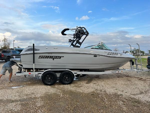 Slide: The Image of 2023 Sanger 231 SL boat on trailer, side view, outdoors. - 0
