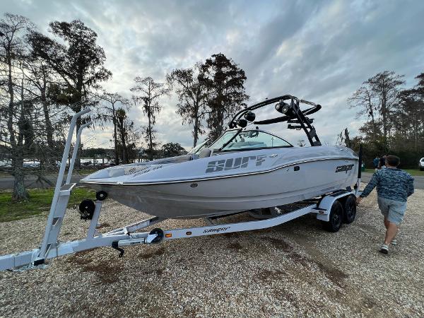 Slide: The Image of 2023 Sanger 231 SL boat on a trailer, parked outdoors. - 1