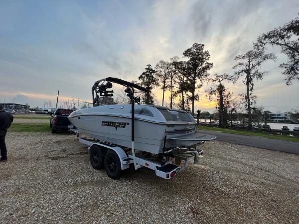 Slide: The Image of 2023 Sanger 231 SL boat on trailer at sunset near marina. - 12
