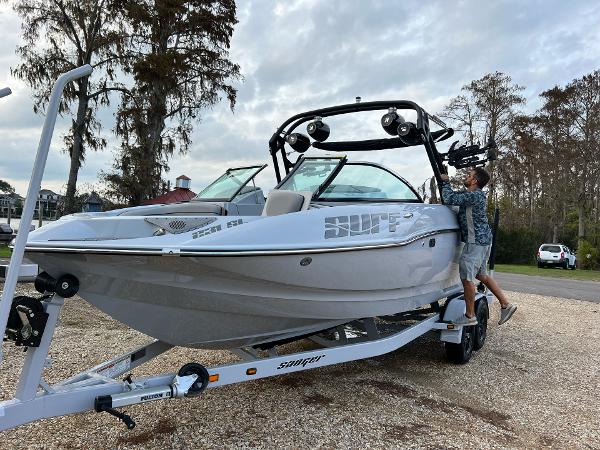 Slide: The Image of 2023 Sanger 231 SL boat on trailer with person adjusting wakeboard tower. - 13