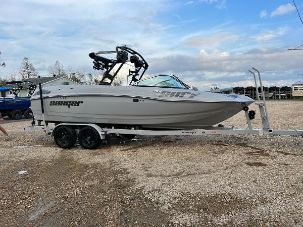 Slide: The Image of 2023 Sanger 231 SL boat on a trailer in a gravel lot. - 14