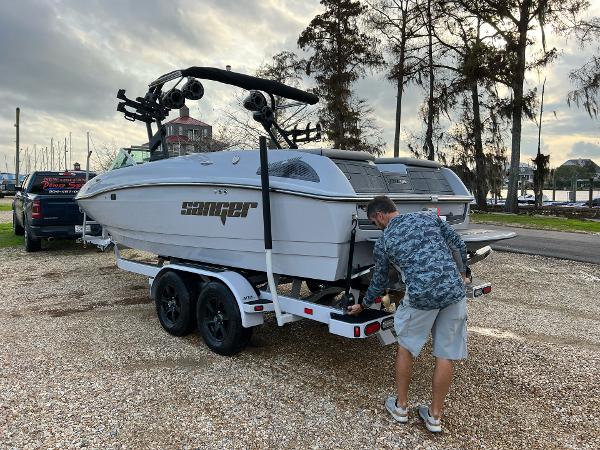 Slide: The Image of Man preparing 2023 Sanger 231 SL boat on trailer at marina. - 15