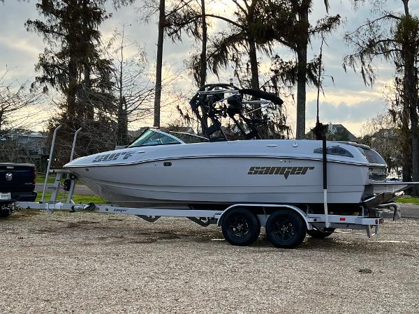 Slide: The Image of 2023 Sanger 231 SL boat on a trailer in a wooded area. - 17