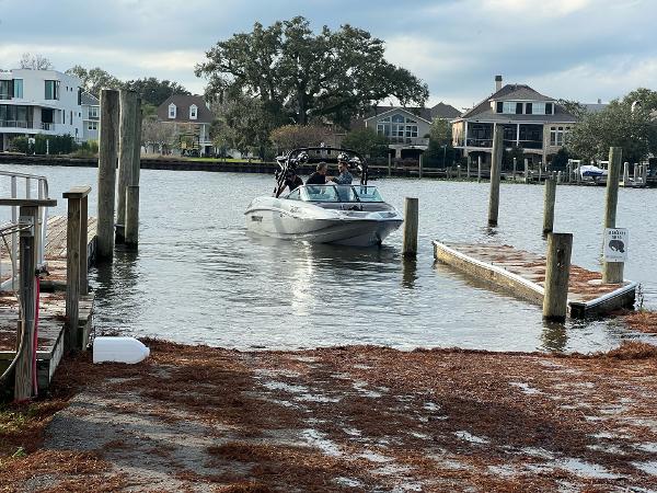 Slide: The Image of 2023 Sanger 231 SL boat docking at a residential marina. - 28
