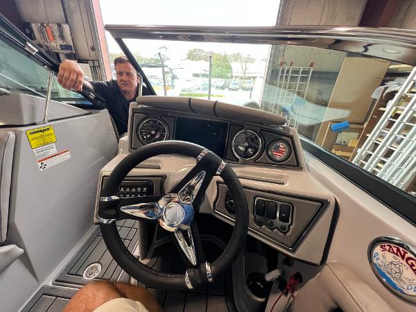 Slide: The Image of 2023 Sanger 231 SL boat dashboard with steering wheel and gauges. - 29