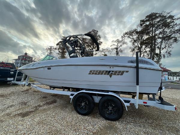 Slide: The Image of 2023 Sanger 231 SL boat on a trailer, parked outdoors under a cloudy sky. - 3