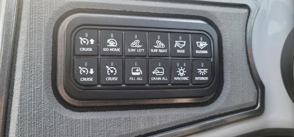 Slide: The Image of Control panel of a 2023 Sanger 231 SL boat with various function buttons. - 38