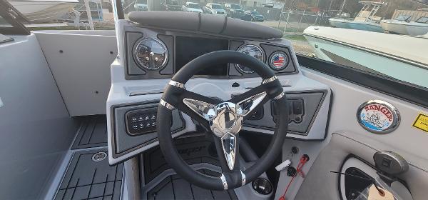 Slide: The Image of Steering console of 2023 Sanger 231 SL boat with modern controls and gauges. - 39