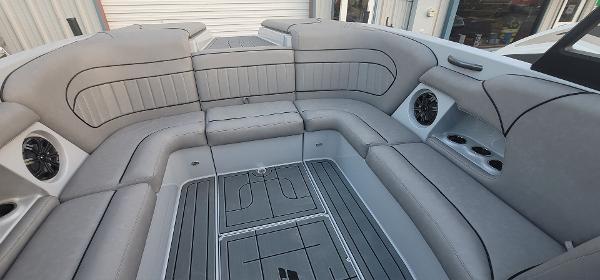 Slide: The Image of 2023 Sanger 231 SL boat interior with gray cushioned seating and built-in speakers. - 42