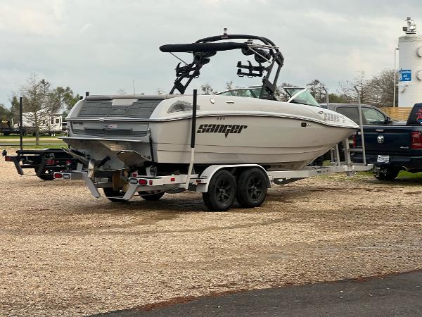 Slide: The Image of 2023 Sanger 231 SL boat on a trailer in a parking lot. - 6