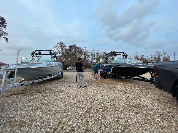 Slide: The Image of Two 2023 Sanger 231 SL boats on trailers with people standing nearby. - 8