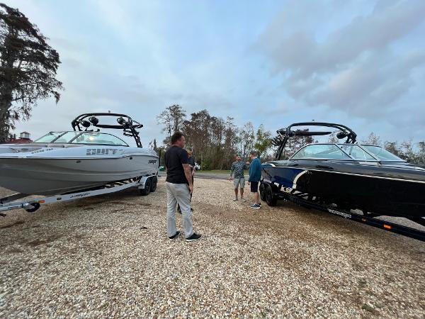 Slide: The Image of People inspecting two 2023 Sanger 231 SL boats on trailers in a gravel lot. - 9